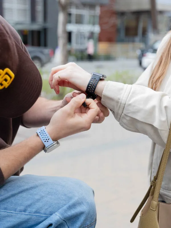 Hands fastening a blue watch band on a wrist