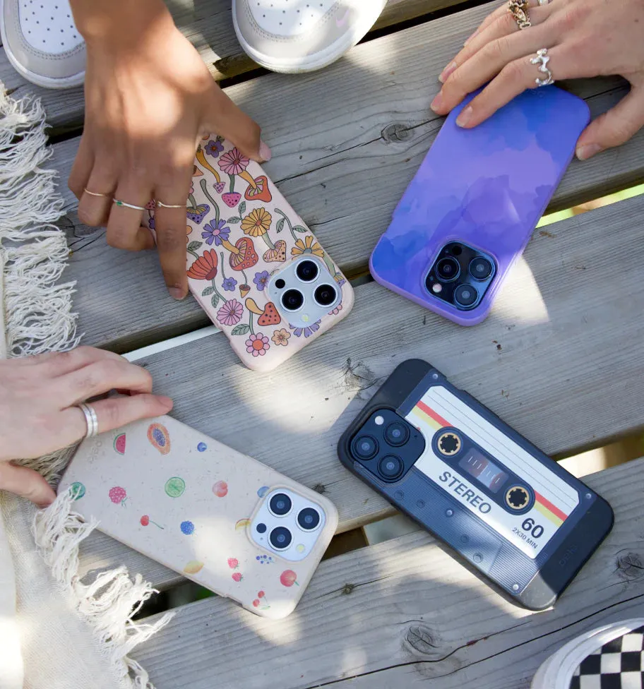Several Pela phone cases with different designs laid out on a picnic table