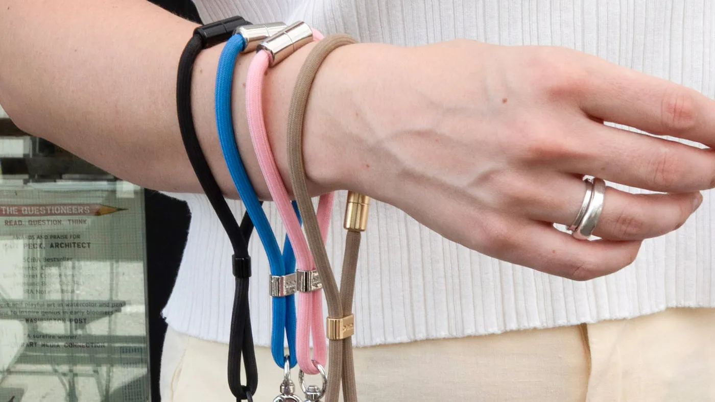 A wrist wearing several colourful phone straps